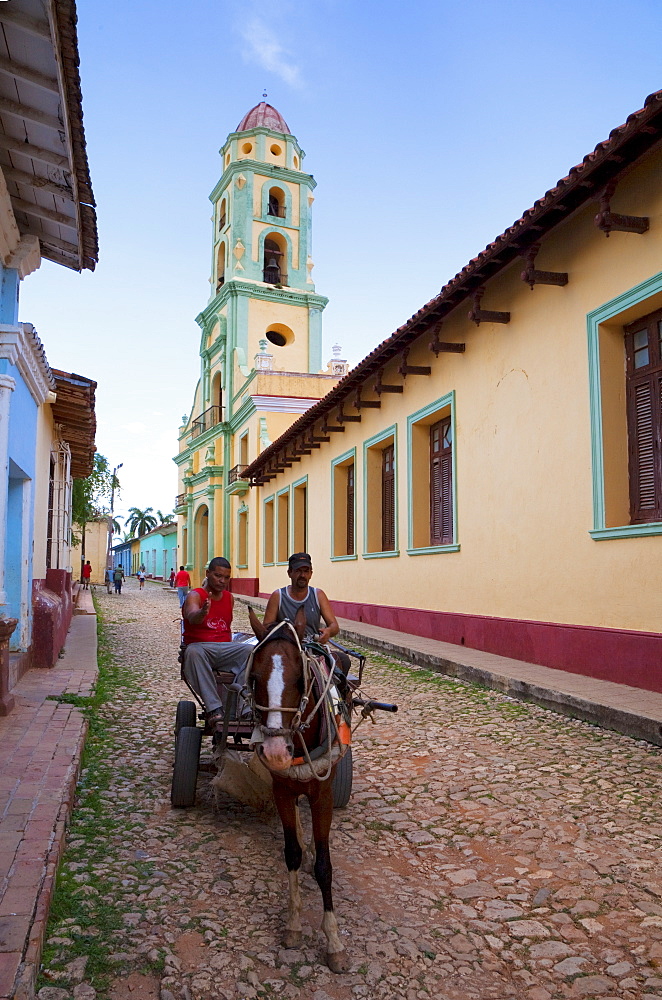 Two men on horse-drawn cart travelling along a quiet street in Trinidad, Sancti Spiritus Province, Cuba, West Indies, Caribbean, Central America