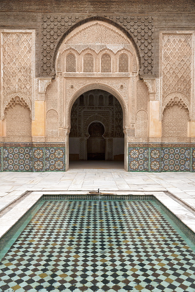 Courtyard and pool with traditional Moroccan ornate doorway in the Ben Youssef Medersa, UNESCO World Heritage Site, Marrakech, Morocco, North Africa, Africa