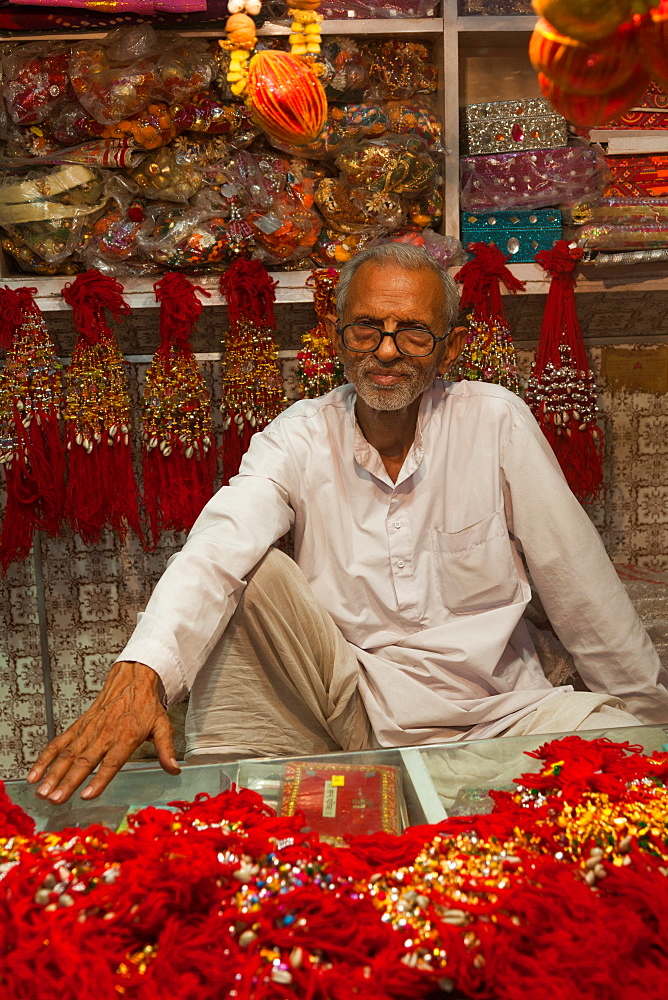 Man in shop selling traditional decorative items in Jaipur, Rajasthan, India, Asia