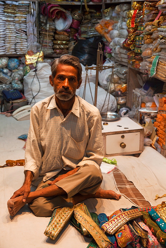 Man selling traditional belts and clothing in the city of Jaipur, Rajaasthan, India, Asia