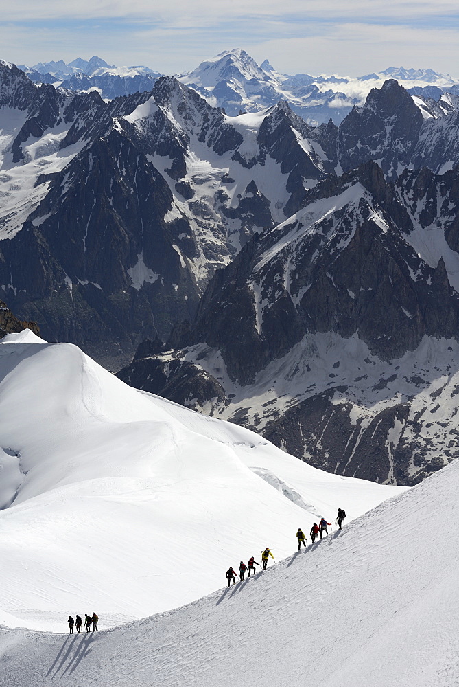 Mountaineers and climbers hiking on a snowy ridge, Aiguille du Midi, Mont Blanc Massif, Chamonix, Haute Savoie, French Alps, France, Europe