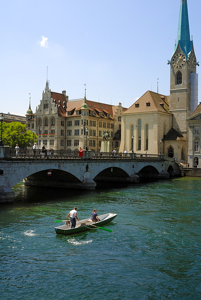 Couple in a boat next to the Munster bridge, on the River Limmat, Zurich, Switzerland, Europe