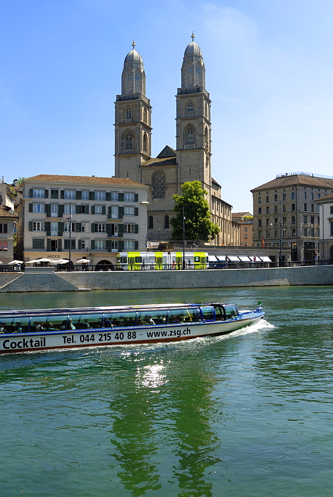 Sightseeing boat on the River Limmat in front of Grossmunster church, Zurich, Switzerland, Europe