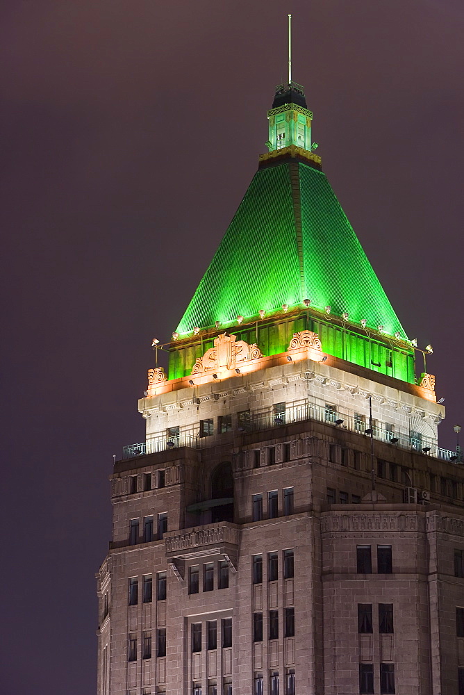 Peace Hotel, one of the historic buildings along the Huangpu river and the famous Bund promenade, illuminated at night, Shanghai, China, Asia