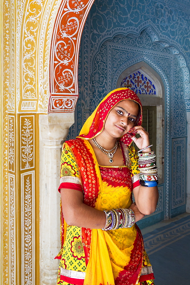 Lady wearing a colourful sari in ornate passageway, Samode Palace, Jaipur, Rajasthan, India, Asia