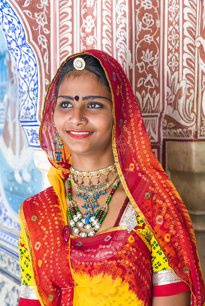 Lady wearing a colourful sari in ornate passageway, Samode Palace, Jaipur, Rajasthan, India, Asia