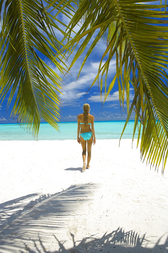 Young woman walking on beach, Maldives, Indian Ocean, Asia