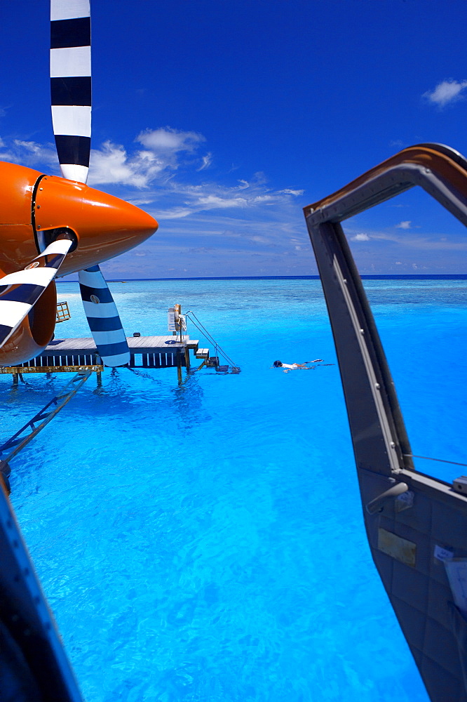 View from a seaplane cockpit of man swimming, Maldives, Indian Ocean, Asia