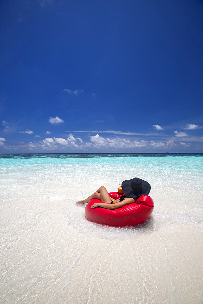 Woman relaxing on the beach, Maldives, Indian Ocean, Asia