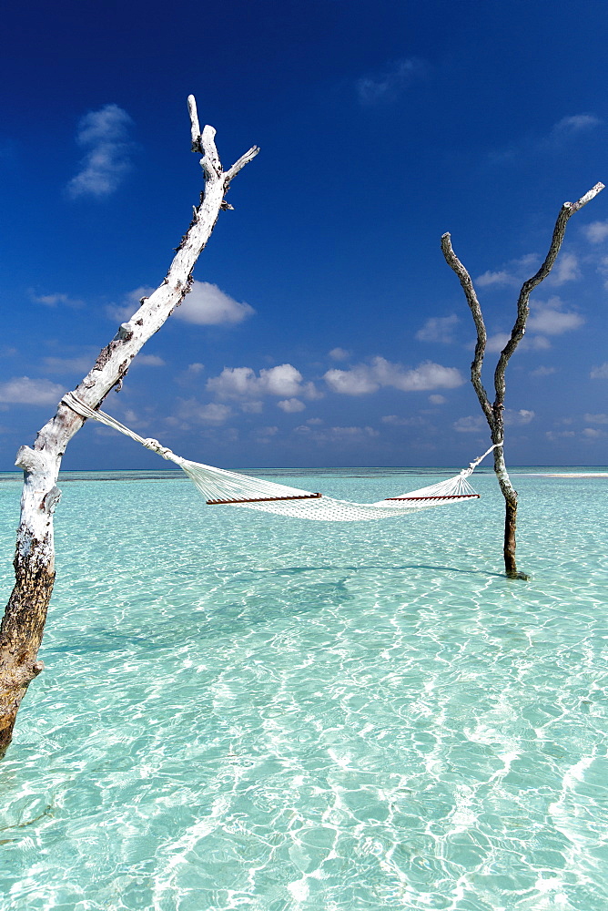 Hammock over the waters of a tropical lagoon, The Maldives, Indian Ocean, Asia