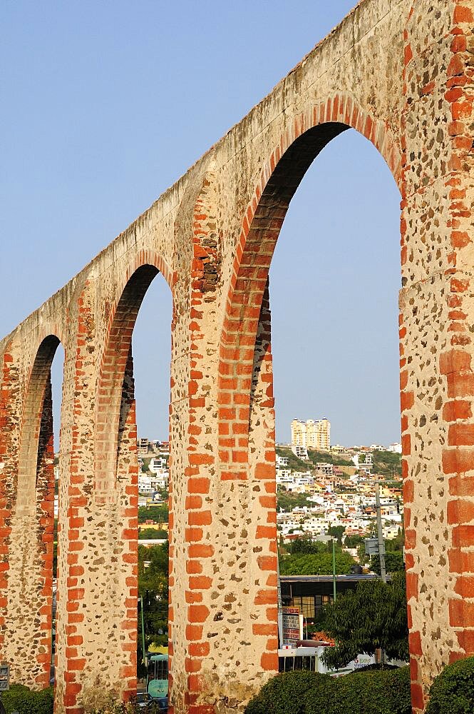 Mexico, The Bajio, Queretaro , Aquaduct arches framing view towards city buildings on hillside beyond.