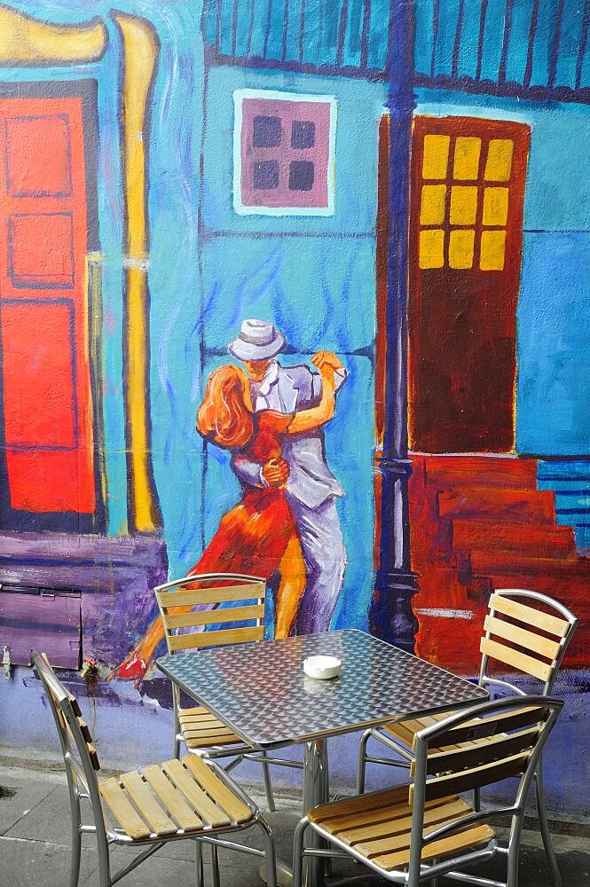 Mexico, Federal District, Mexico City, Condesa District Argentinian restaurant with painted exterior depicting couple dancing the tango and table and chairs in foreground.1