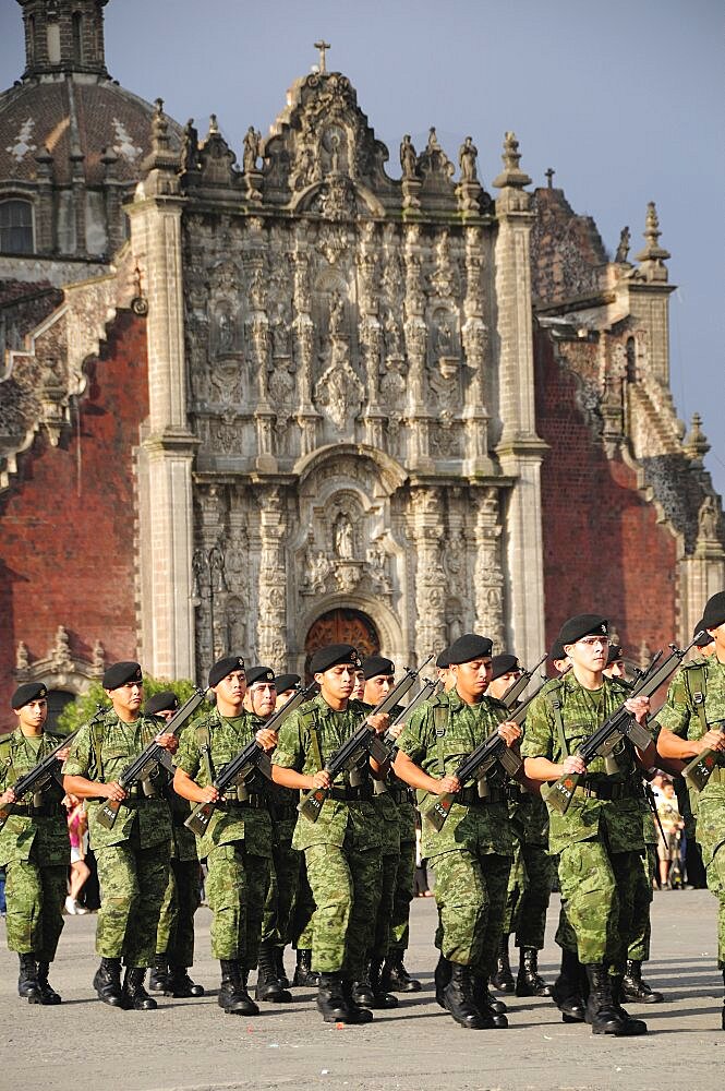 Mexico, Federal District, Mexico City, Military parade of the flag lowering ceremony in the Zocalo with the Cathedral behind.