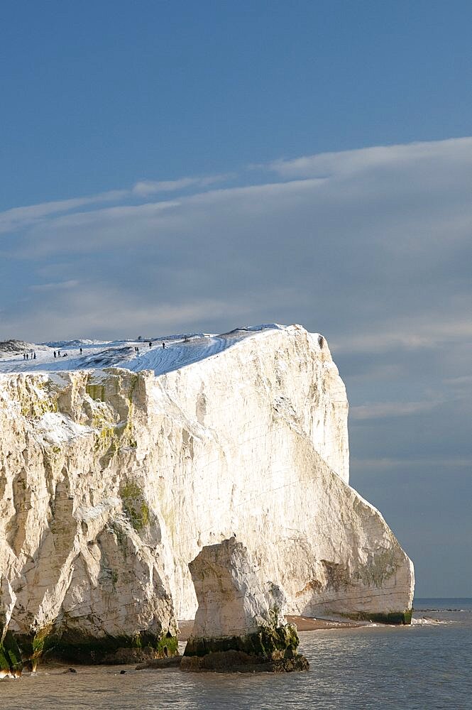 England, East Sussex, Seaford Head, Snow on cliffs with people toboganing.