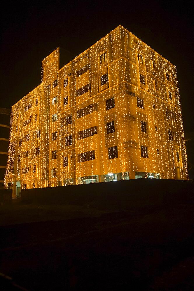 Bangladesh, Dhaka, Gulshan Apartment block at night lit up for a wedding with strings of fairy lights cascading over the side.