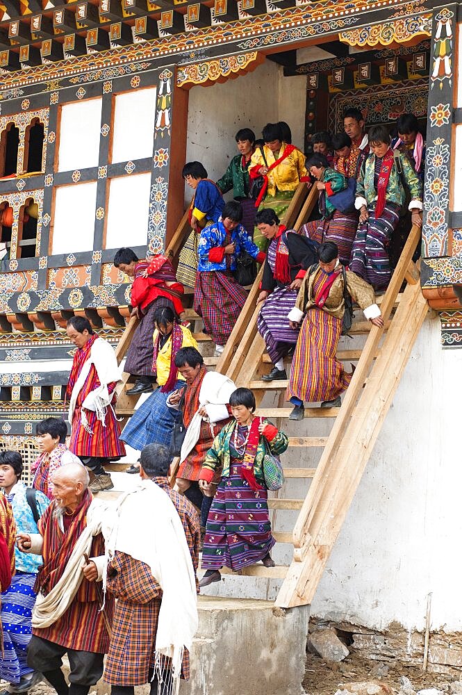 Bhutan, Gangtey Gompa, Tsecchu festival crowds descending temple steps dressed in their best clothes.