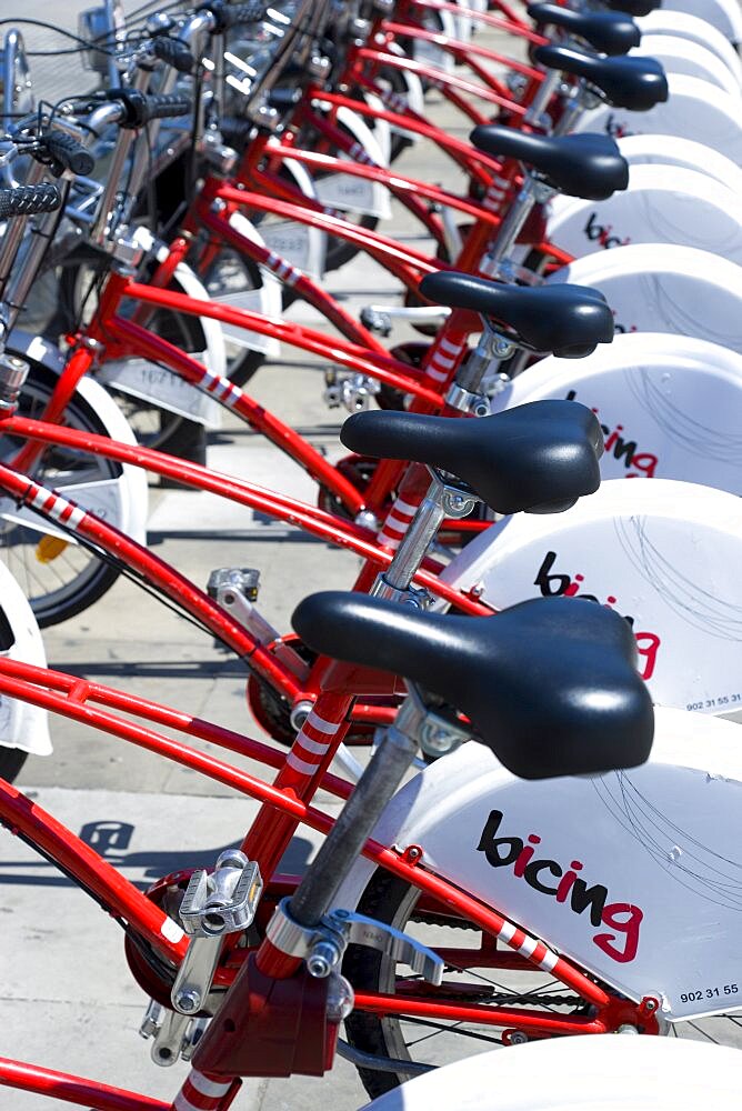 Spain, Catalonia, Barcelona, Red and white Bicing public hire bicycles in the Parc de la Ciutadella in the Old Town district.