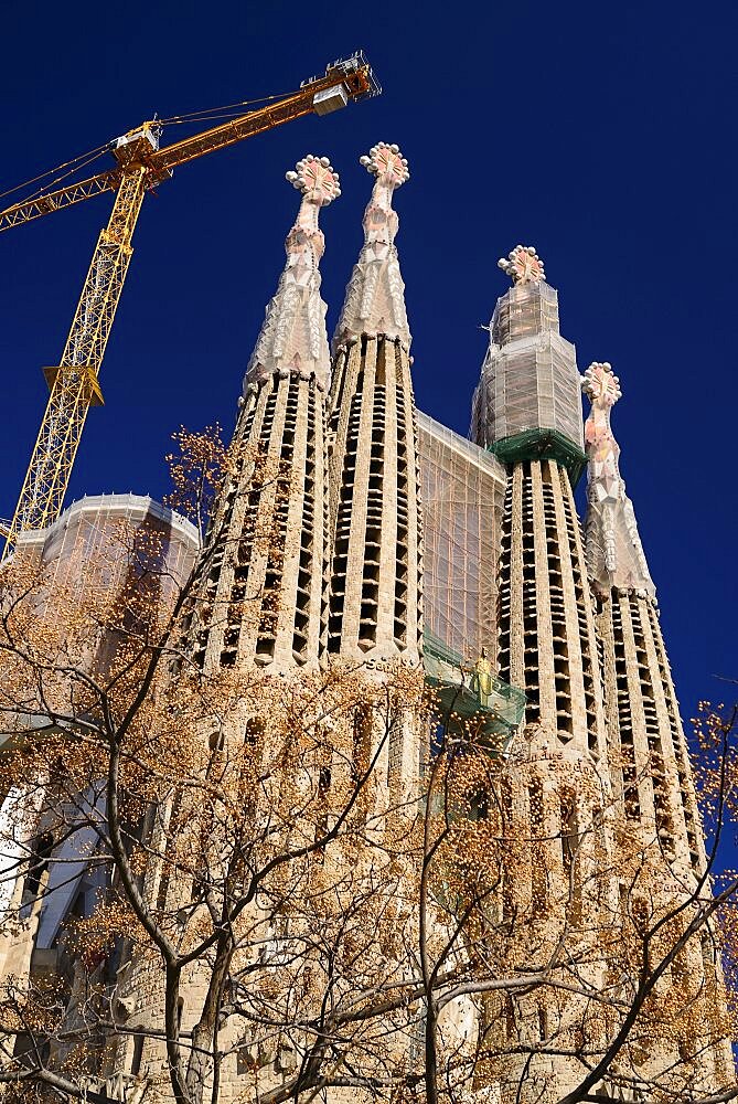 Spain, Catalonia, Barcelona, Basilica i Temple Expiatori de la Sagrada Familia, Generally known as Sagrada Familia, General view of the Passion Facade with crane hanging above.