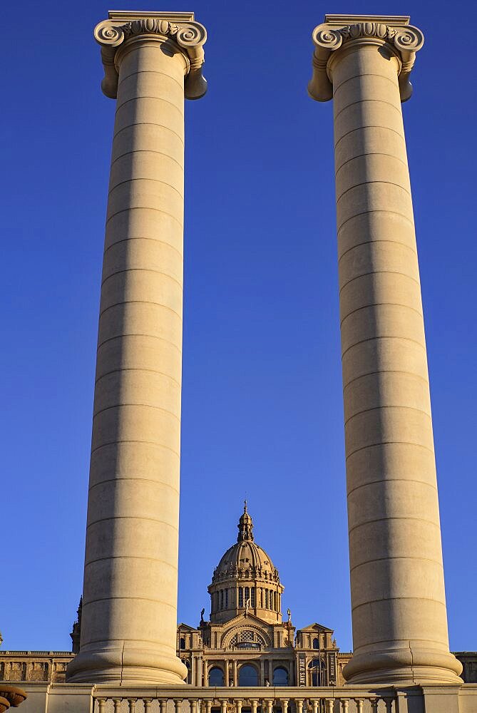 Spain, Catalunya, Barcelona, Montjuic, View through pillars of the Palau Nacional which was built for the 1929 International Exhibition in Barcelona and now houses the National Art Museum of Catalonia.