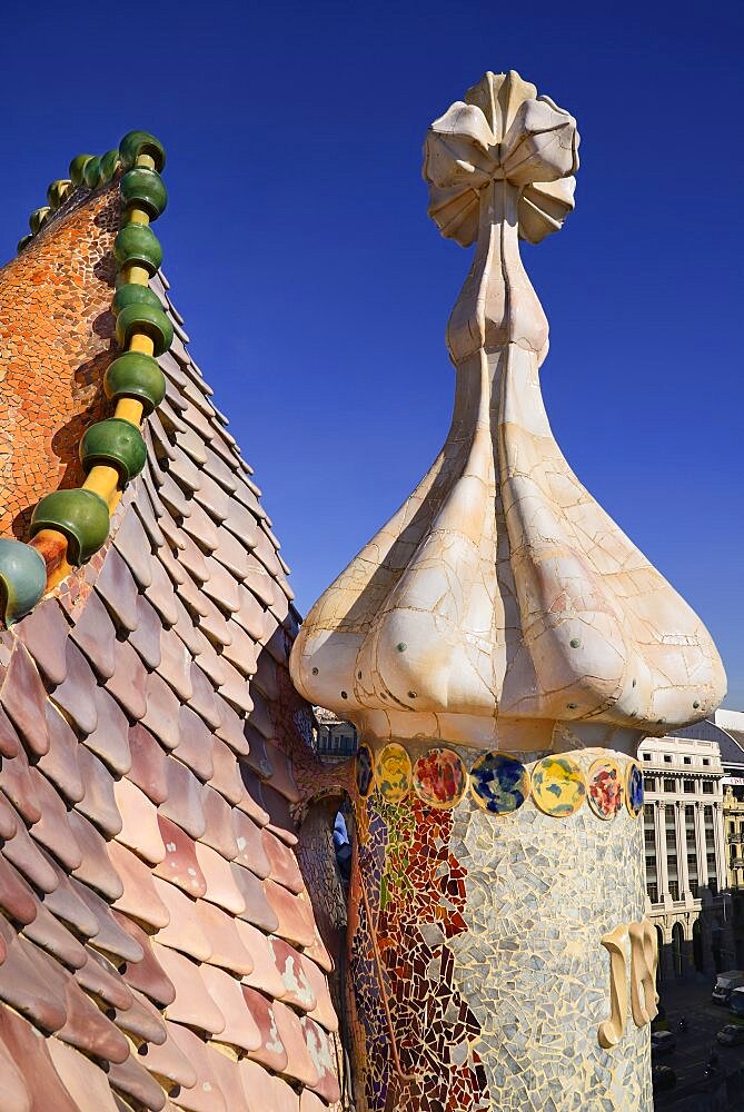 Spain, Catalunya, Barcelona, Antoni Gaudi's Casa Batllo building, dragon's back feature on the roof terrace with the four armed cross also inclluded.