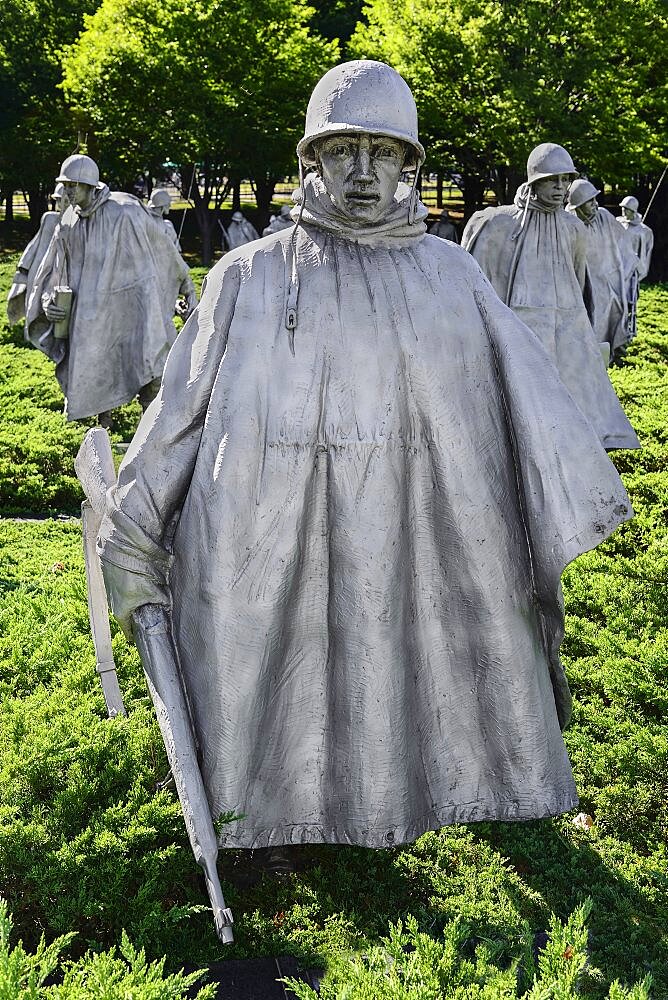 USA, Washington DC, National Mall, Korean War Veterans Memorial, Statues of soldiers on patrol in combat gear among juniper bushes.