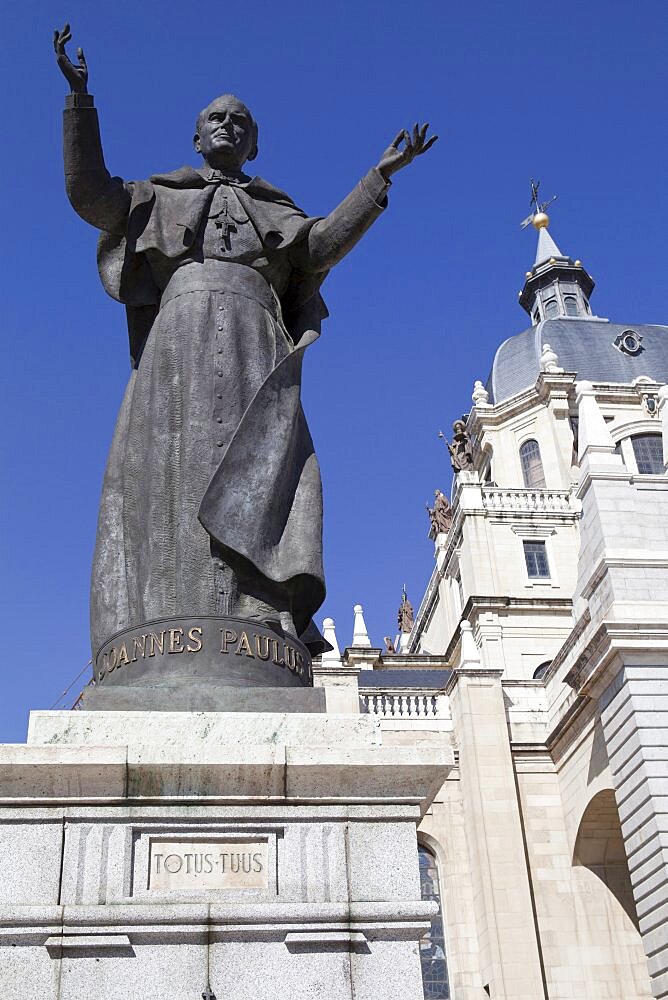 Spain, Madrid, Cathedral de la Almudena with statue of Pope John Paul II in the courtyard.