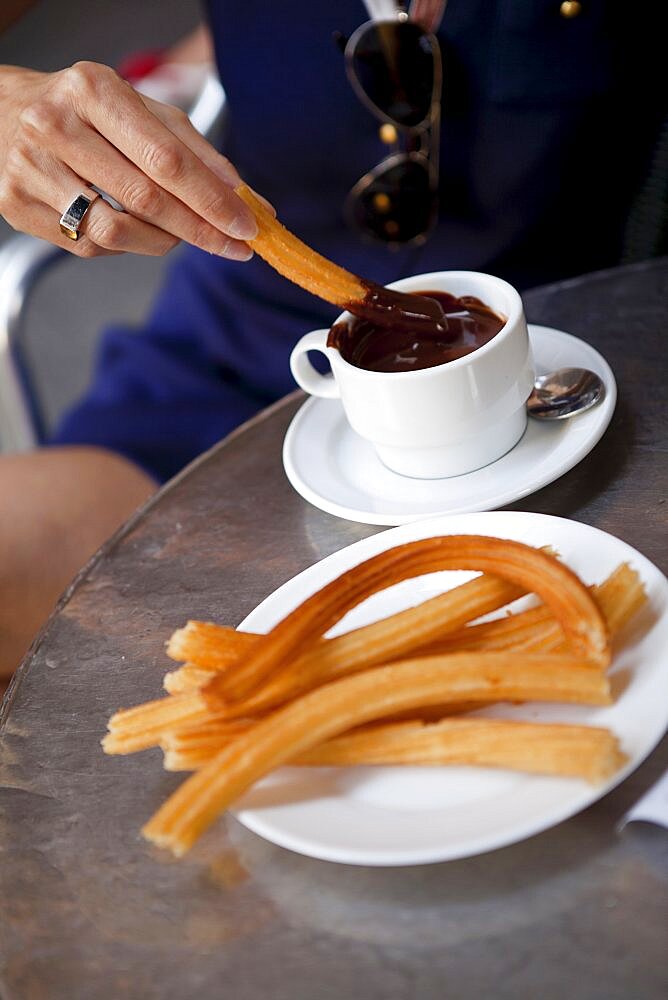 Spain, Madrid, Eating churros with hot chocolate.