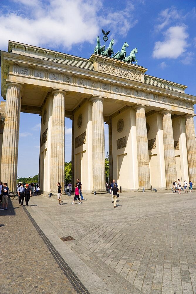 Germany, Berlin, Mitte, sightseeing tourists at the Brandenburg Gate or Brandenburger Tor in Pariser Platz leading to Unter den Linden and the Royal Palaces with the Quadriga of Victory on top. The only remaining of the original 18 gates in the Berlin Customs Wall.