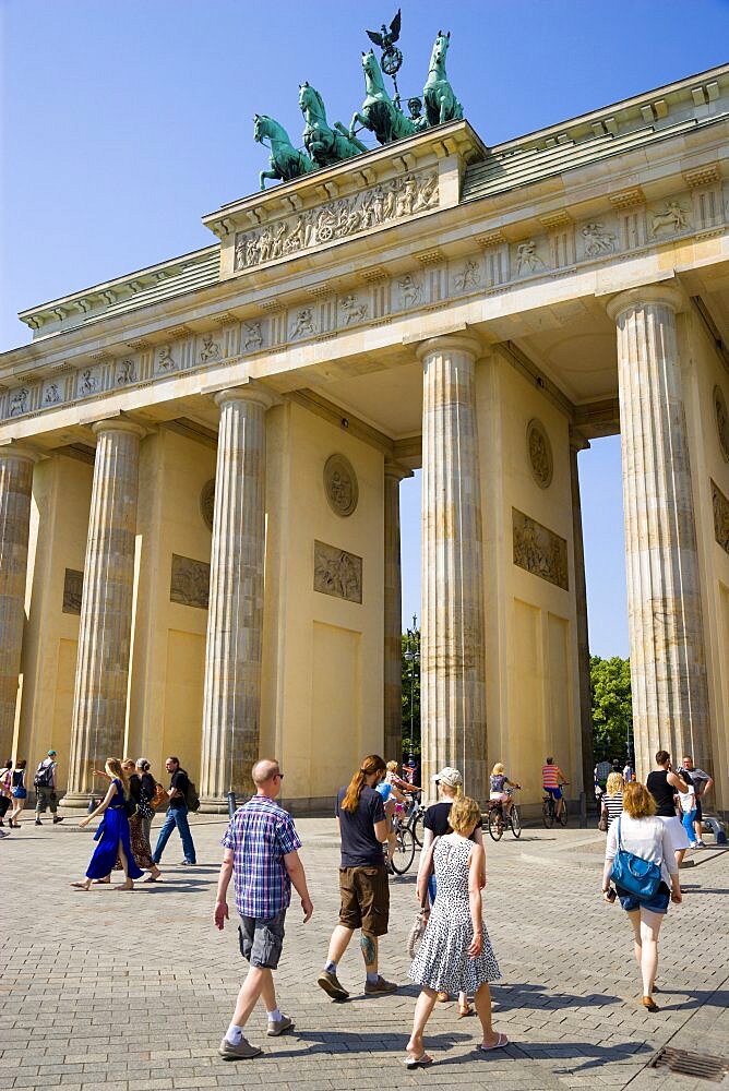 Germany, Berlin, Mitte, sightseeing tourists at the Brandenburg Gate or Brandenburger Tor in Pariser Platz leading to Unter den Linden and the Royal Palaces with the Quadriga of Victory on top. The only remaining of the original 18 gates in the Berlin Customs Wall.