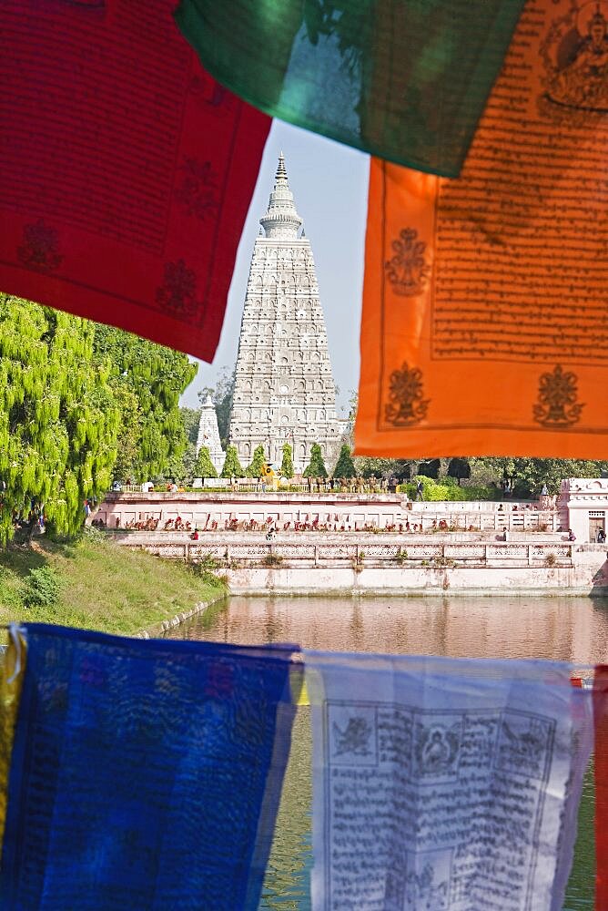 India, Bihar, Bodhgaya, Mahabodhi Temple framed by colourful Buddhist prayer flags.