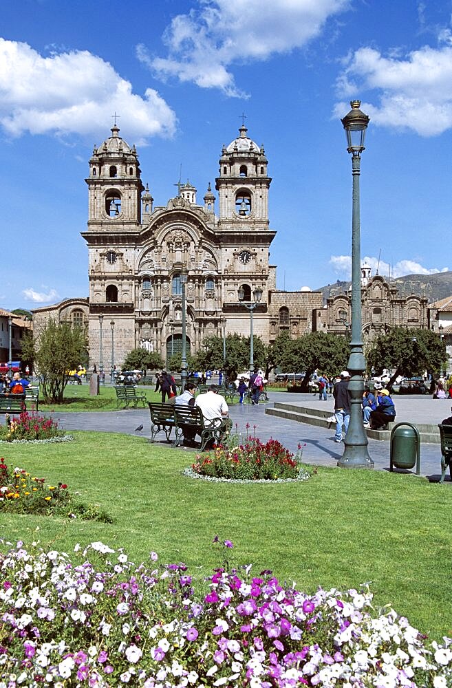 PERU  Cusco Looking across Plaza de Armas to Iglesia La Compania de Jesus. Cuzco Travel Tourism Holiday Vacation Explore Recreation Leisure Sightseeing Tourist Attraction Tour Destination Plaza De Armas Cusco Cuzco Peru Peruvian South Southern America Latin Sacred Valley Of The Inca Incas Vivid Vibrant City Town Square Tranquil Tranquility Tradition Traditional Culture Cultural Buildings Architecture Architectural Ethnic UNESCO World Heritage Site Andes Andean View Vista Spanish Colonial Scenic Picturesque Backdrop People Visitors Park Garden Path Pathway Iglesia La Compania Jesus Jesuit Church Churches Religion Religious Pray Prayer Worship Worshipping Worshiping Christianity Holy Divine Christian Theology Faith Sacred Devout Catholic Catholicism Spectacular Beautiful Quiet Blue Sky Magnificent Lawn Grass Flowers Calendar American South America