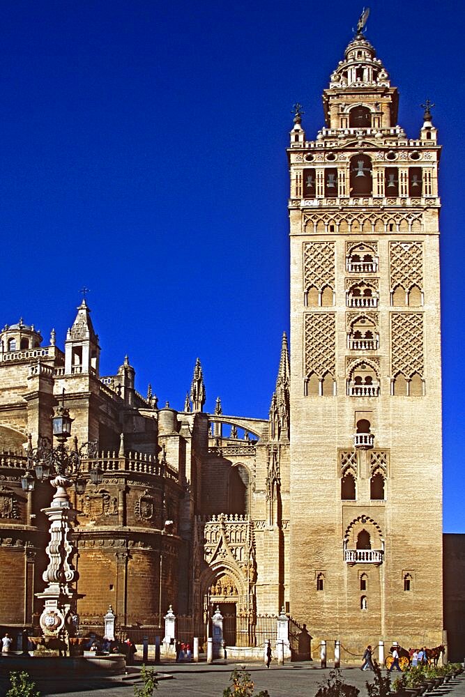 SPAIN Andalucia Seville Cathedral  Plaza Virgen de los Reyes. Travel Tourism Holiday Vacation Explore Recreation Leisure Sightseeing Tourist Attraction Tour Destination Trip Journey Seville Sevilla Andalucia Andalucian Andalusia Andalusian Spain Spanish Espana Europe European Union EU Blue Sky City Culture Cultural Building Architecture Architectural History Historic Historical Landmark Square UNESCO World Heritage Site Iglesia Cathedral Catedral Church Churches Religion Religious Pray Prayer Worship Worshipping Worshiping Christianity Holy Divine Christian Theology Faith Sacred Devout Catholic Catholicism Impressive Majestic Faade Edifice Bell Tower Spire Steeple Spectacular Beautiful Magnificent Gothic Style Vacation Espainia Espanha Espanya European Union Hispanic Religion Religious Christianity Christians Southern Europe