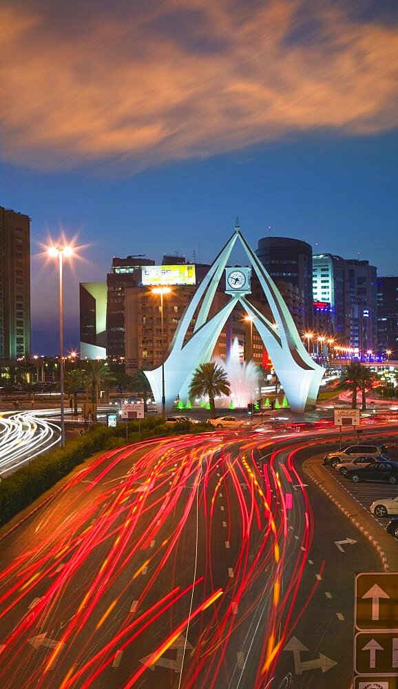 UAE  Dubai The Clock Tower roundabout in Rigga at dusk. Modern Architecture Middle East Dubai UAE Asia Holidays Tourism Travel United Arab Emirates Traffic Red Sunset Clock Time Transport Blur Al-Imarat Al-Arabiyyah Al-Muttahidah Arabic Asian Dubayy Emiriti