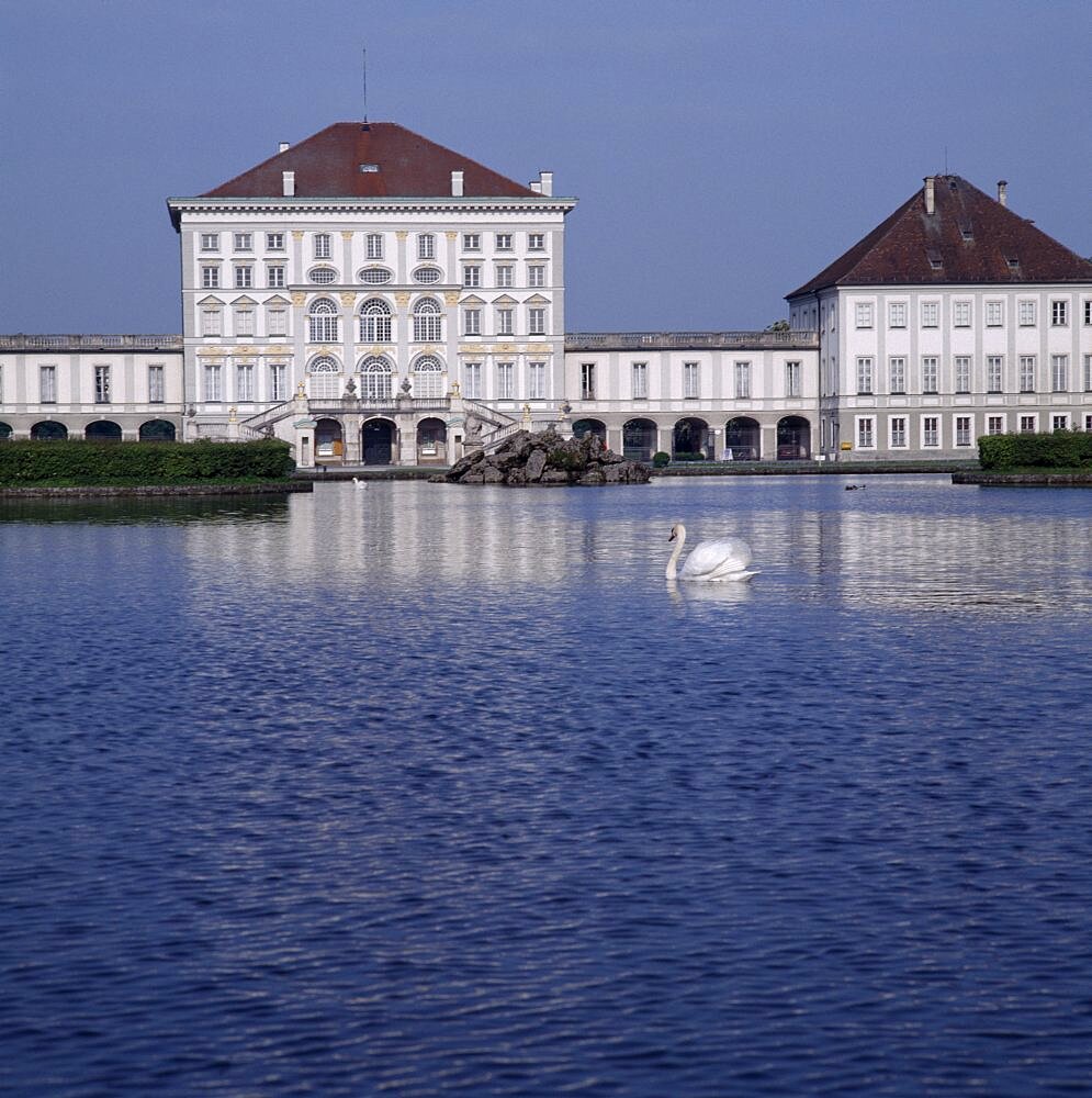 Schloss Nymphenburg, Viewed across canal with reflection and swan on water, Munich, Bavaria, Germany