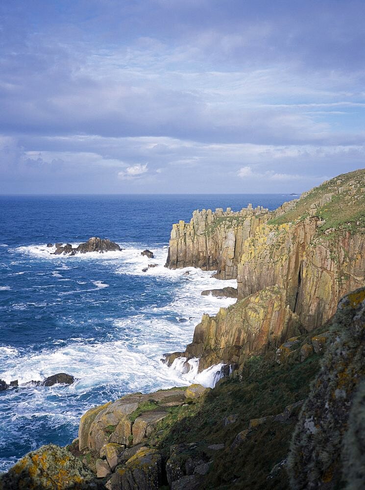 Waves breaking against eroded sea cliffs in winter, Lands End, Cornwall, England, United Kingdom