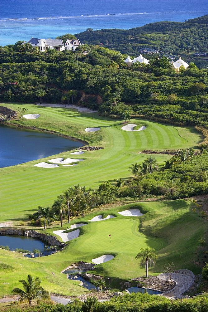 Raffles Resort Trump International Golf Course designed by Jim Fazio, The 16th green which is the longest par 3 in the world the 17th fairway with the resort and coral reef beyond, Canouan, St Vincent & The Grenadines