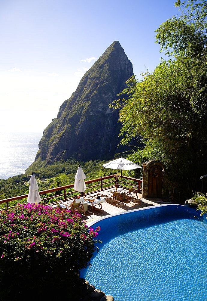 Val des Pitons Tourists sunbathing on the sun deck beside the pool at Ladera Spa Resort Hotel overlooking Petit Piton volcanic plug and Jalousie beach, Soufriere, St Lucia