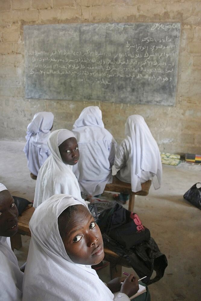 Tanji Village, African Muslim girls wearing white headscarves attending a class at the Ousman Bun Afan Islamic school, Girls in foreground looking back towards the camera, Tanji, Western Gambia, The Gambia