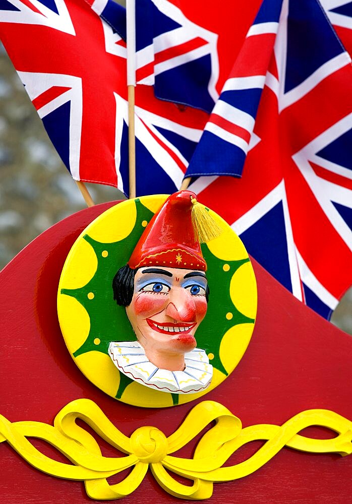 Findon village Sheep Fair Bright red Punch and Judy stand with Union Jack flags and a carved image of Punch, United Kingdom