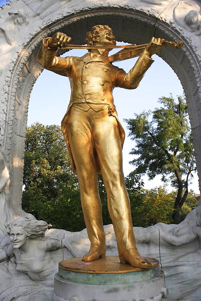 Austria, Vienna, Statue of Johann Strauss in the Stadt Park framed by stone arch.