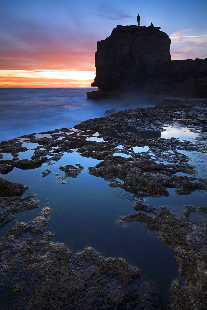 A man stands atop Pulpit Rock watching the sun setting, Portland, Jurassic Coast, UNESCO World Heritage Site, Dorset, England, United Kingdom, Europe