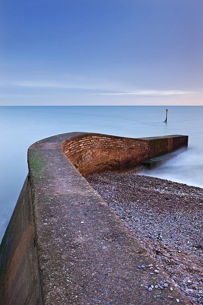 Stone jetty on Sidmouth beachfront at sunset, Sidmouth, Devon, England, United Kingdom, Europe