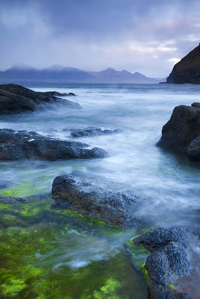 Looking towards the island of Kalsoy from the rocky shores of Gjogv, Eysturoy, Faroe Islands, Denmark, Europe