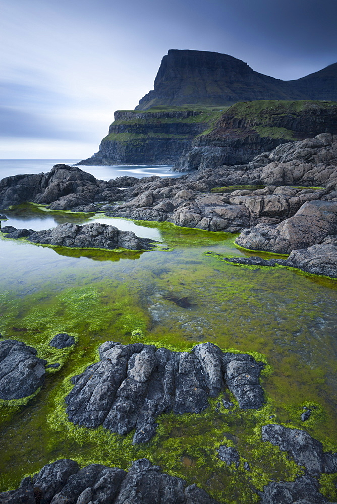 Algae lined rockpools on the coast at Gasadalur on the island of Vagar, Faroe Islands, Denmark, Europe 