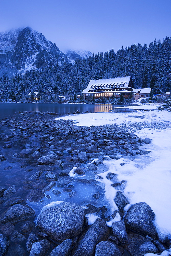 Frozen lake shore and Mountain House at twilight in winter, Popradske Pleso, High Tatras, Slovakia, Europe 