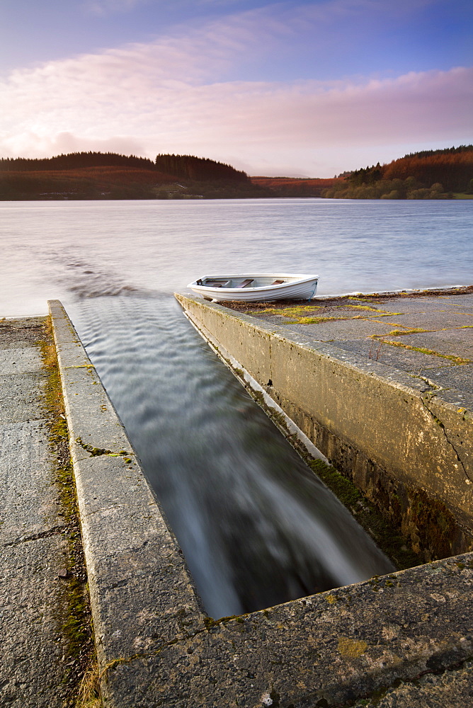 Usk Reservoir outflow and boat in winter, Brecon Beacons National Park, Carmarthenshire, Wales, United Kingdom, Europe 