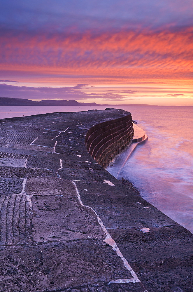 Spectacular winter sunrise above The Cobb harbour wall, Lyme Regis, Dorset, England, United Kingdom, Europe 