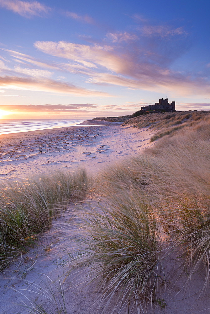 Sunrise over Bamburgh Beach and Castle from the sand dunes, Northumberland, England, United Kingdom, Europe