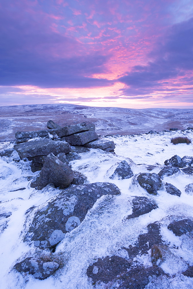 Beautiful sunrise in winter over a frozen snow covered moorland, Belstone Tor, Dartmoor, Devon, England, United Kingdom, Europe