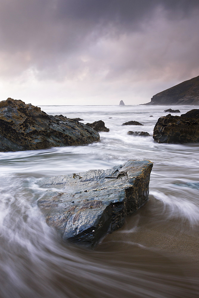 Incoming tide swirling around rocks on Tregardock Beach, North Cornwall, England, United Kingdom, Europe